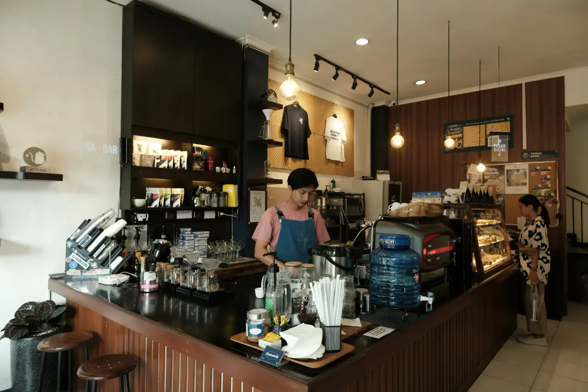 A barista at work behind the counter of a small coffee shop