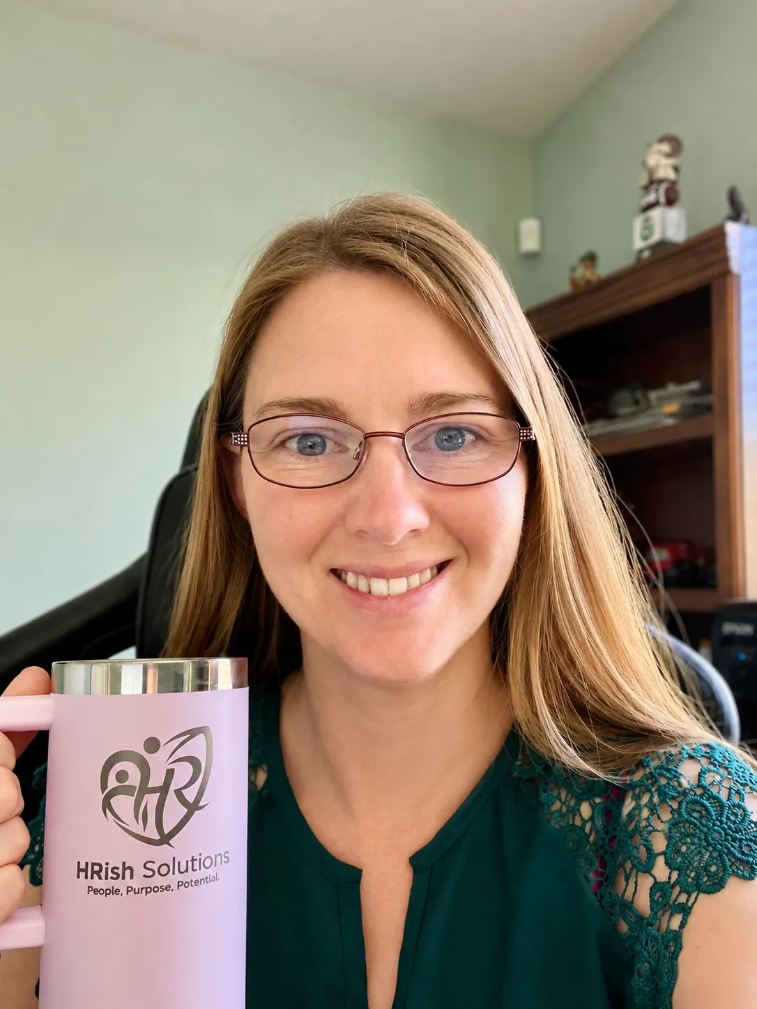 Allisha McCartney smiling and holding an HRish Solutions tumbler