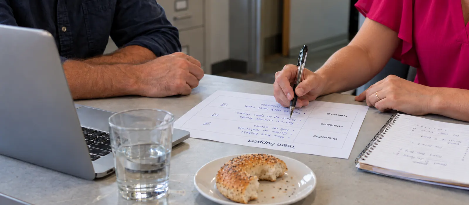 Allisha McCartney writing on a Team Support checklist at a table with a client