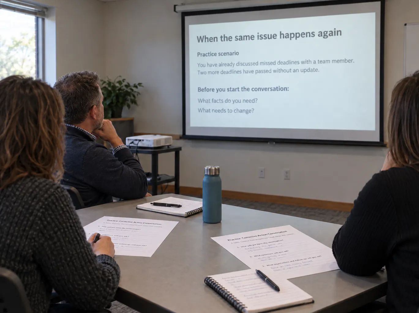 A training session: three people at a table with worksheets, watching a slide titled When the same issue happens again